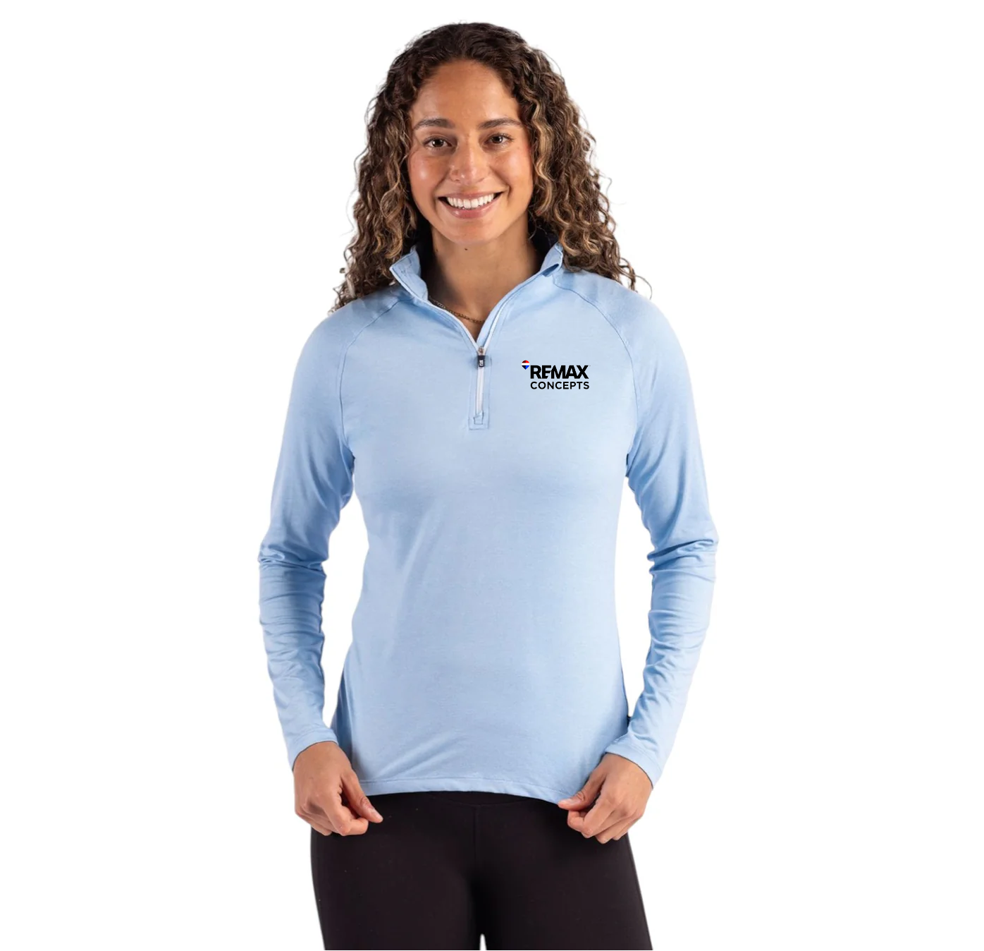 A woman modeling a light blue long-sleeve quarter-zip athletic pullover with a black and white 'REMAX CONCEPTS' logo on the left chest, paired with black leggings, against a solid white background.