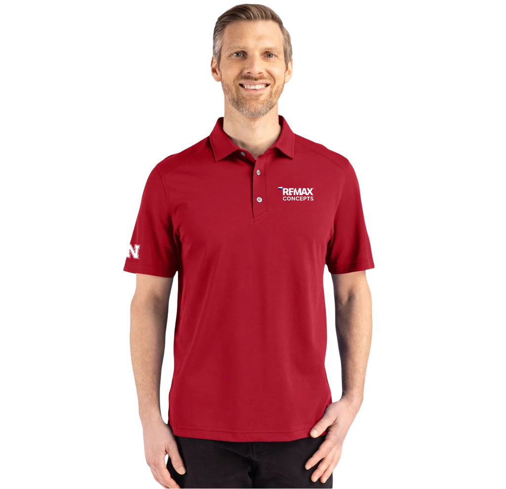 A man wearing a red short-sleeve polo shirt with white printed logos on the left chest and right sleeve, photographed against a plain white background.
