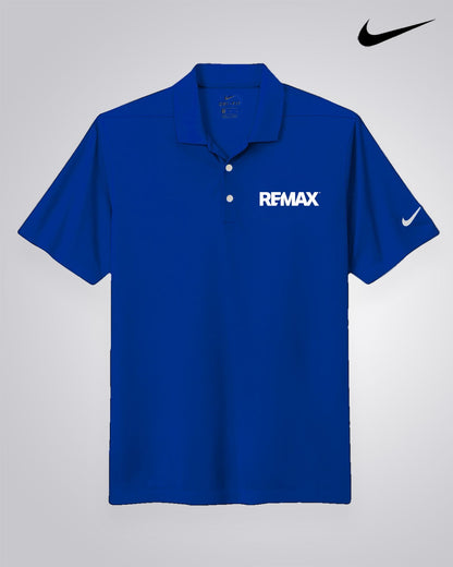 A royal blue short-sleeve polo shirt with 'RFMAX' printed in white on the left chest and a white Nike swoosh on the right sleeve, displayed against a light gray gradient background with a black Nike swoosh logo in the top right corner.