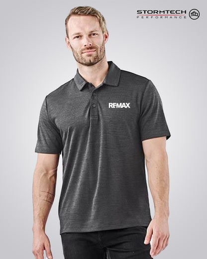 A man wearing a dark gray heathered short-sleeve polo shirt with 'REMAX' printed in white on the left chest, shown against a light gray studio background. The 'STORMTECH PERFORMANCE' logo is visible in the top right corner.