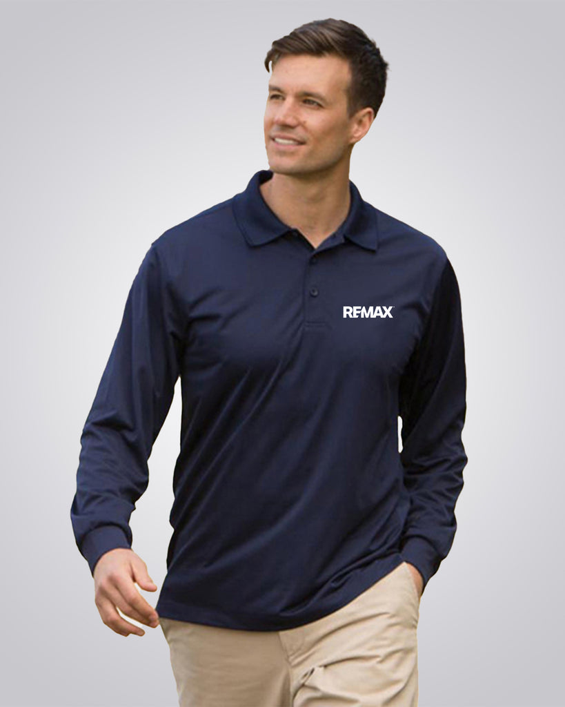 A man wearing a navy blue long-sleeve polo shirt with the white REMAX logo on the left chest, paired with khaki pants, against a light gray studio background.