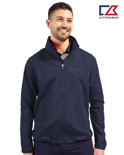 Man wearing a navy jacket with a visible brand logo on a white background