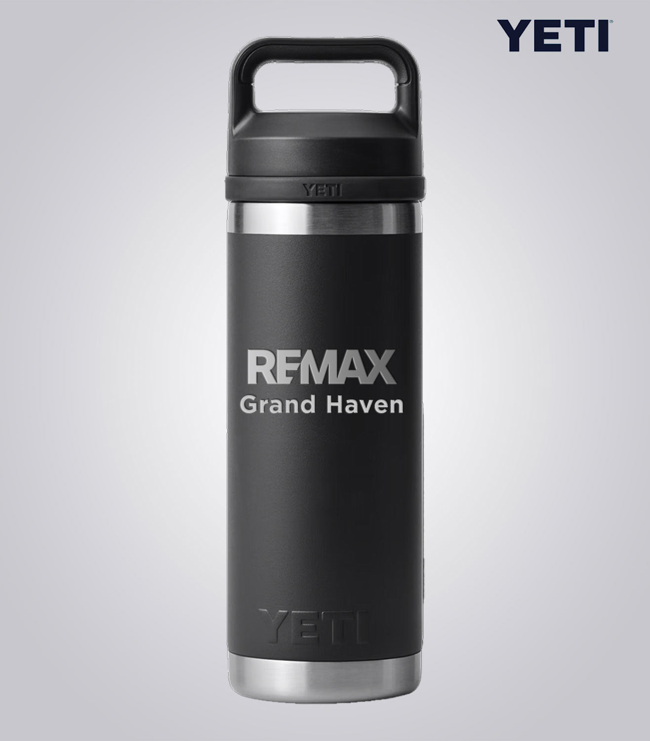 Black YETI mug with 'REMAX Grand Haven' text on a light gray background