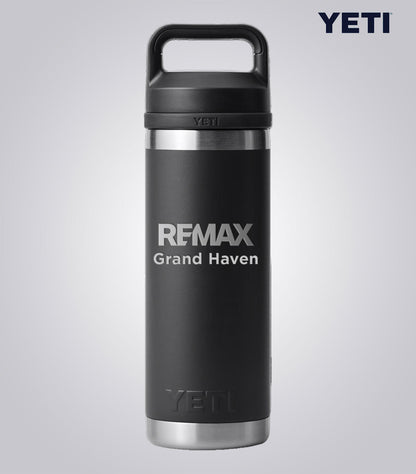 Black YETI mug with 'REMAX Grand Haven' text on a light gray background