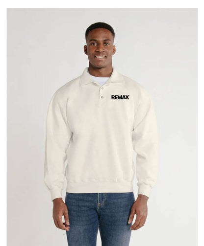 A man wearing a cream-colored long-sleeve polo sweatshirt with a black 'REMAX' logo on the chest, paired with blue jeans, against a light gray studio background.