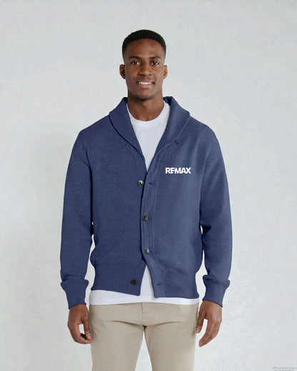 A man wearing a navy blue cardigan with a white 'RFMAX' logo on the chest, layered over a white t-shirt and beige pants, standing against a light gray textured background.