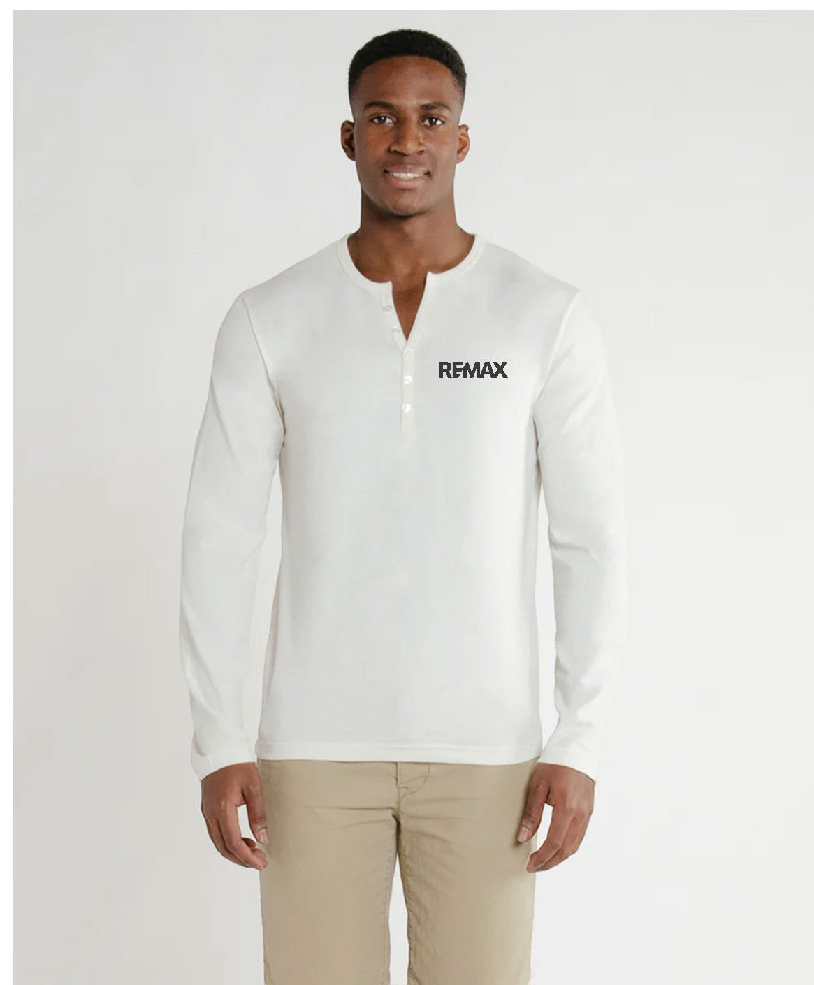 Man wearing a white shirt with 'REMAX' logo on a plain background