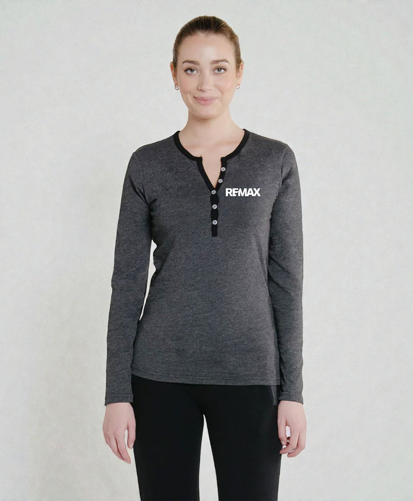 A woman modeling a dark gray long-sleeve henley shirt with black trim and a white REMAX logo on the chest, paired with black pants, against a light gray studio background.