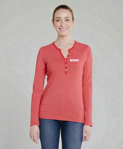 A woman wearing a coral red long-sleeve henley shirt with the brand name 'REMIX' printed in white on the left chest, paired with blue jeans, against a neutral gray background.