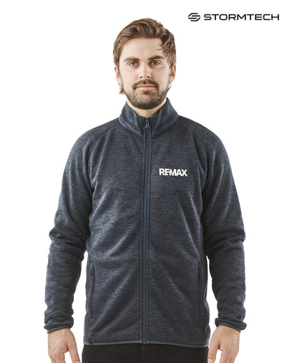Man wearing a gray jacket with REMAX logo on a white background, featuring Stormtech branding.