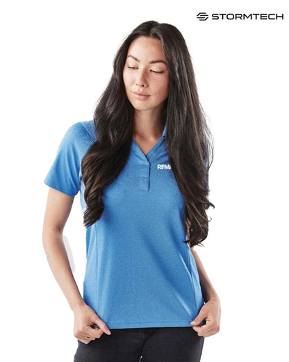 Woman wearing a blue polo shirt with a visible brand logo on a white background