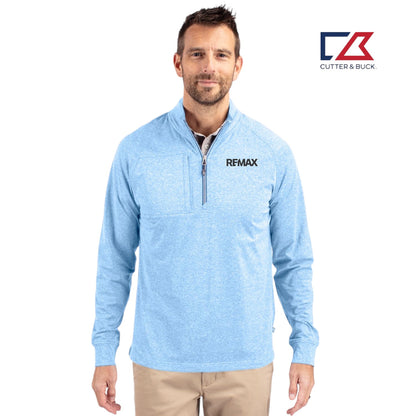 Man wearing a light blue pullover with 'REMAX' logo, standing against a white background with Cutter & Buck logo.