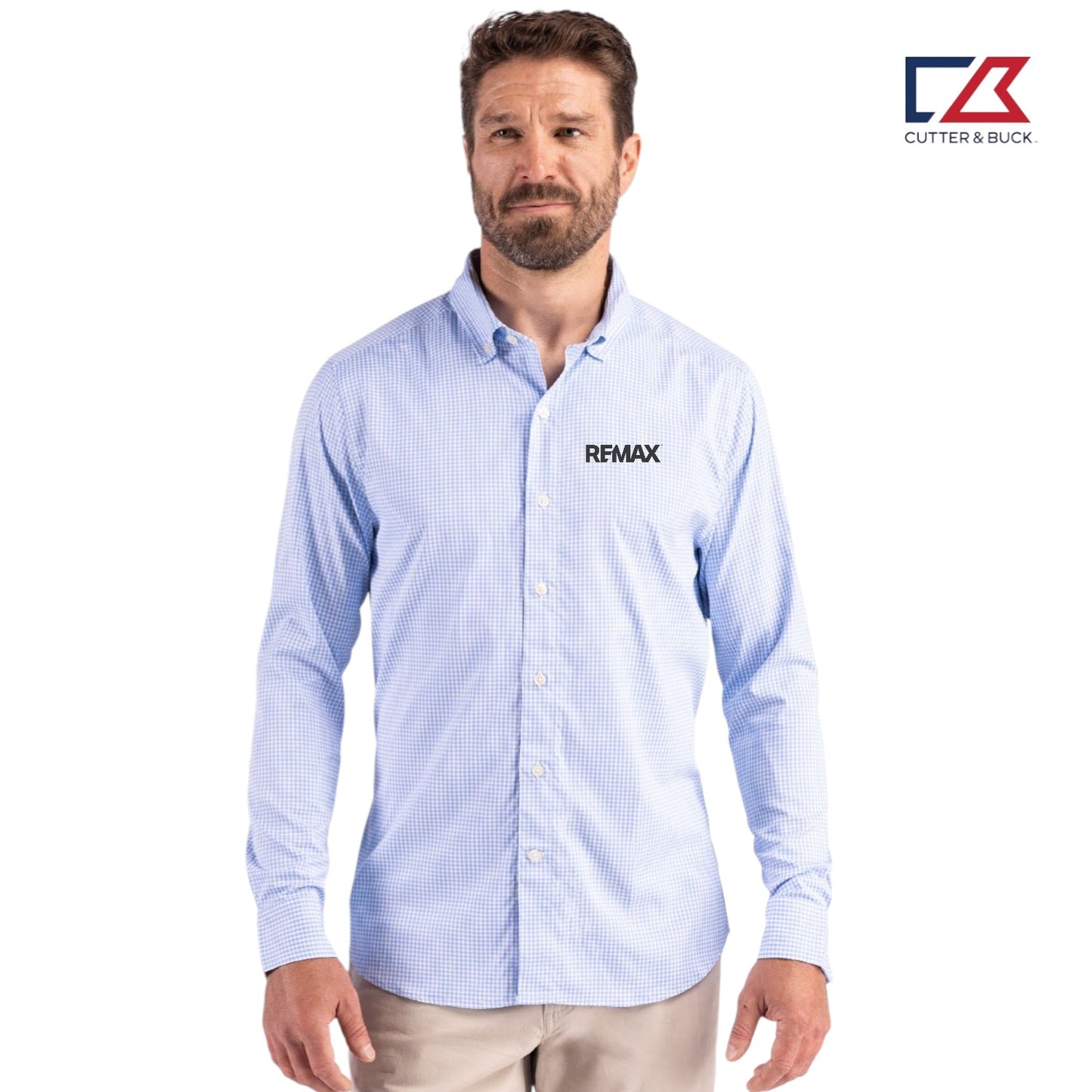 Man wearing a light blue checkered shirt with 'REMAX' logo, standing against a white background with Cutter & Buck logo.