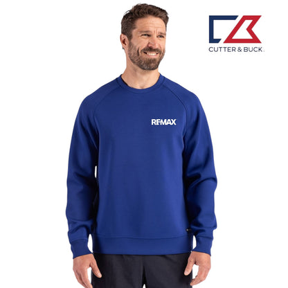 Man wearing a blue sweatshirt with 'REMAX' logo, standing against a white background with Cutter & Buck logo.