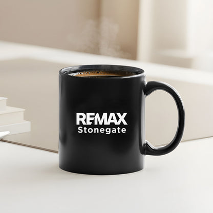 Black mug with REMAX Stonegate logo on a light surface
