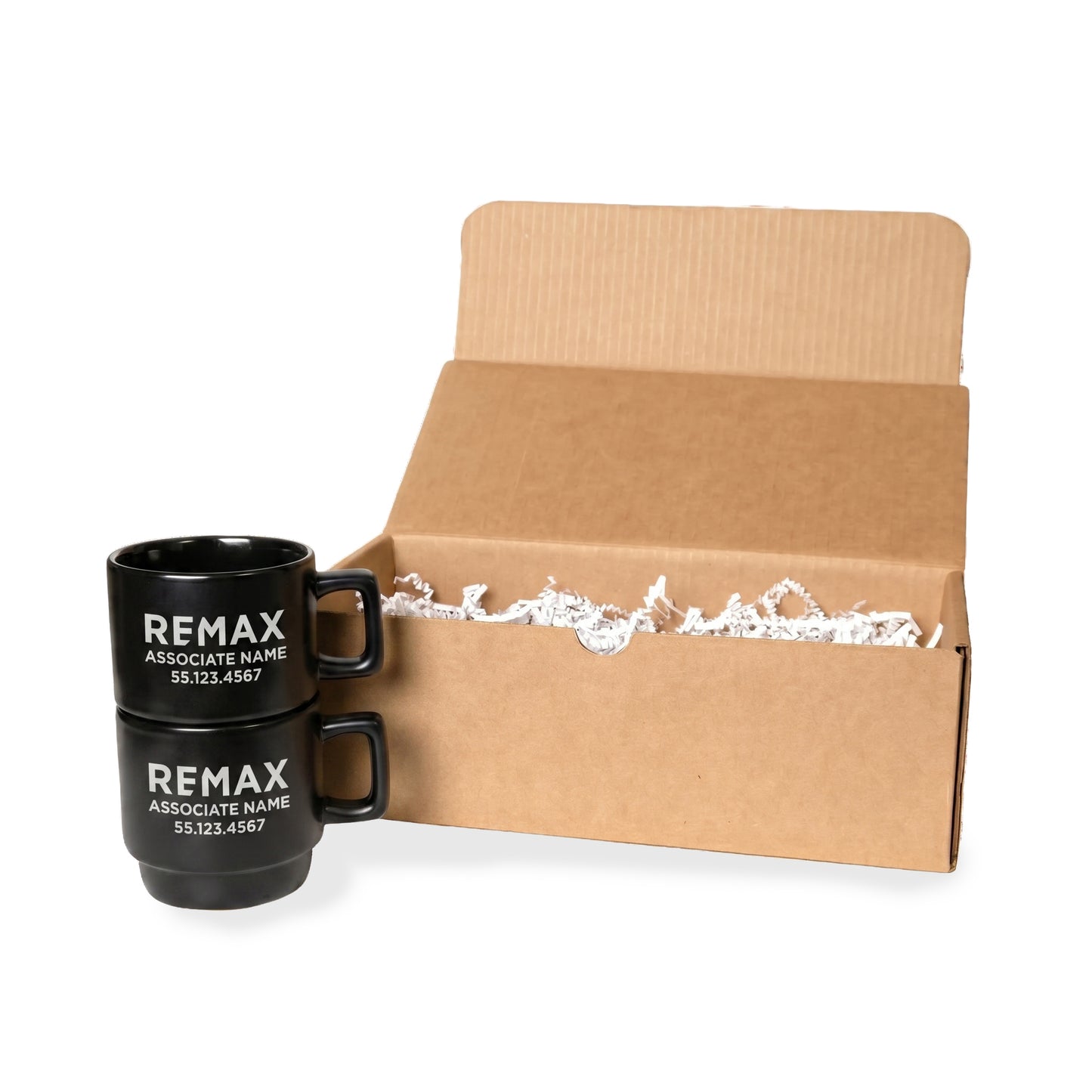 Two black REMAX mugs in front of an open cardboard box on a white background