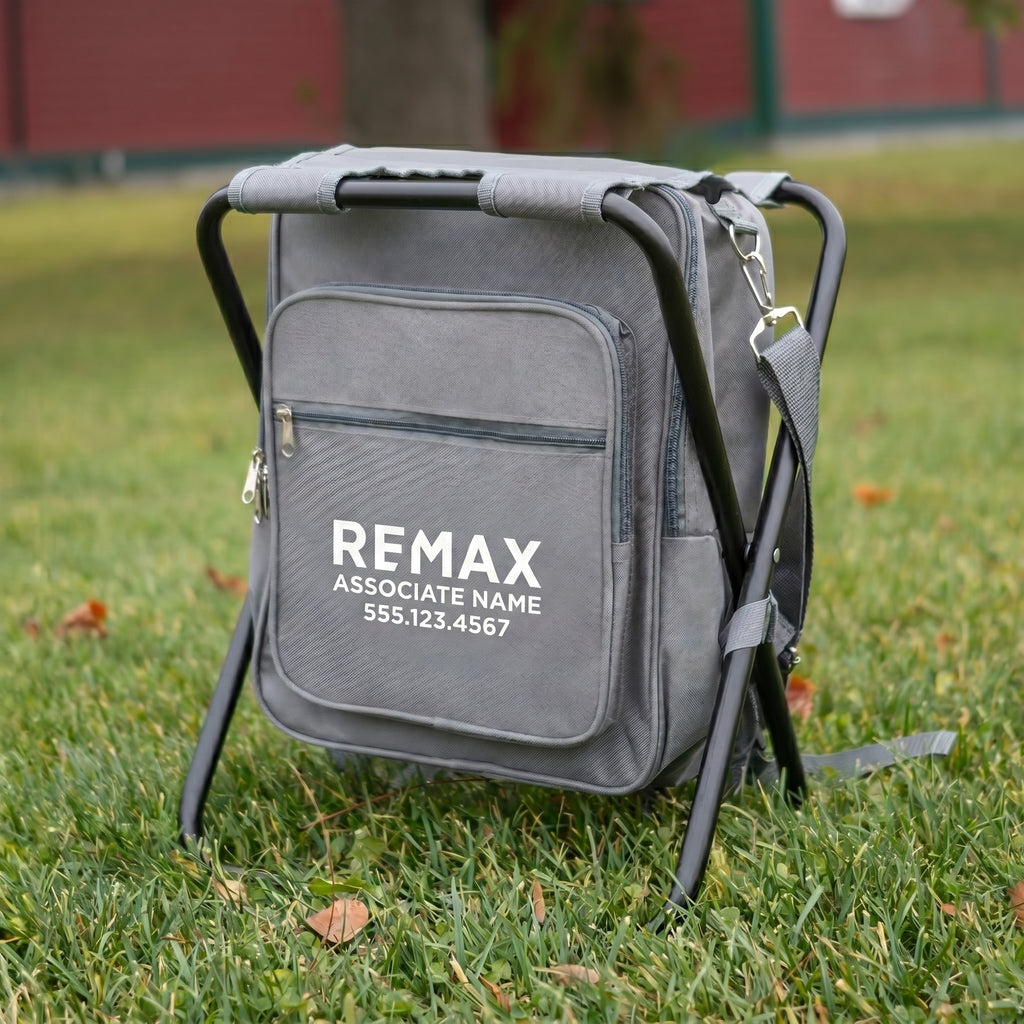 Gray backpack with REMAX branding on a grassy field