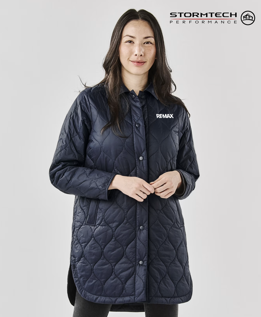 Woman wearing a black quilted jacket with REMAX branding on a white background, featuring Stormtech Performance logo.