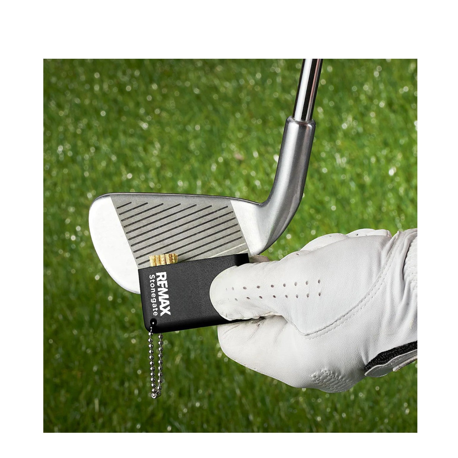 Golf club with a Remax storage device attached, held by a gloved hand on a grass background