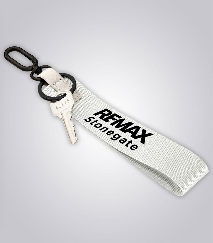 Keychain with key and 'REMAX Stonegate' tag on a light gray background