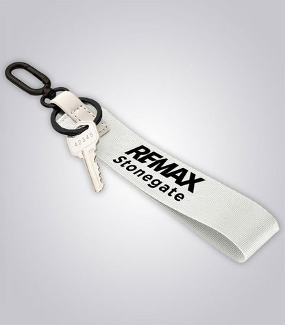 Keychain with key and 'REMAX Stonegate' tag on a light gray background