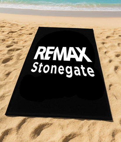 Black mat with 'REMAX Stonegate' text on a sandy beach