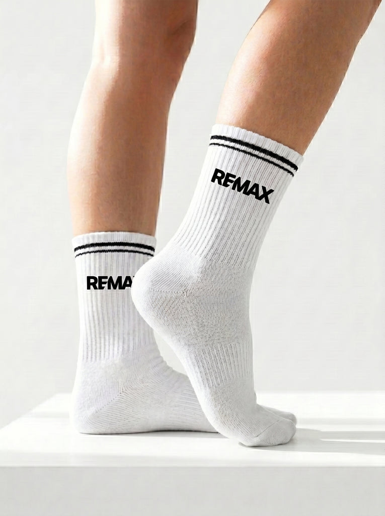 White socks with 'REMAX' branding worn by a person on a light gray background