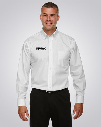 A man wearing a white long-sleeve button-down shirt with a black REMAX logo on the left chest, paired with black trousers, against a light gray studio background.