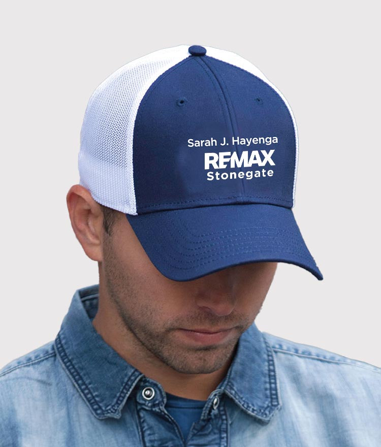 Person wearing a blue and white cap with 'REMAX Stonegate' branding on a light gray background