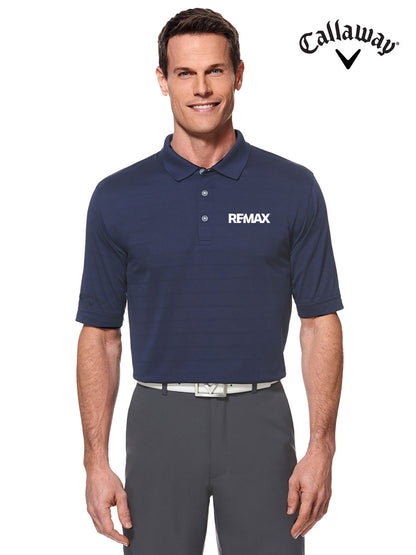 A man wearing a navy Callaway REMAX polo shirt with gray trousers, shown against a plain white background with the Callaway logo in the top right corner.