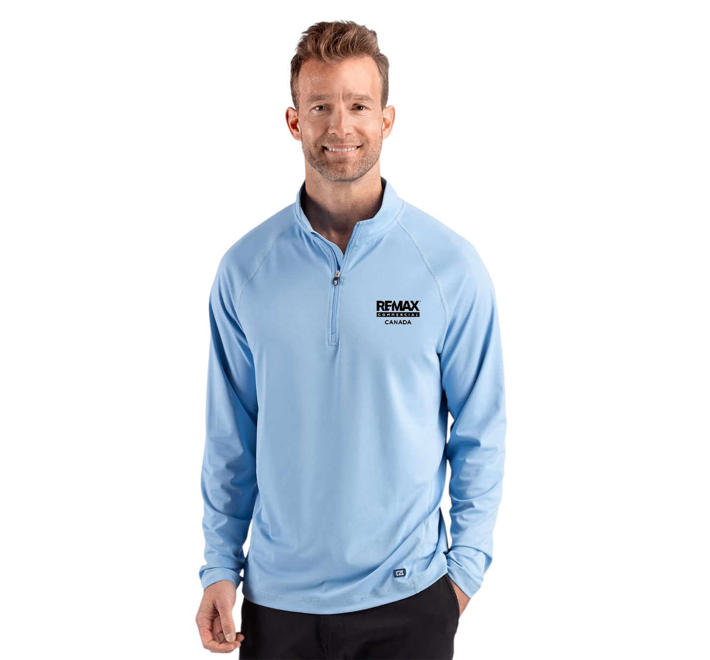 A man wearing a light blue long-sleeve quarter-zip pullover with a black 'REMAX' logo on the left chest, photographed against a solid white background.