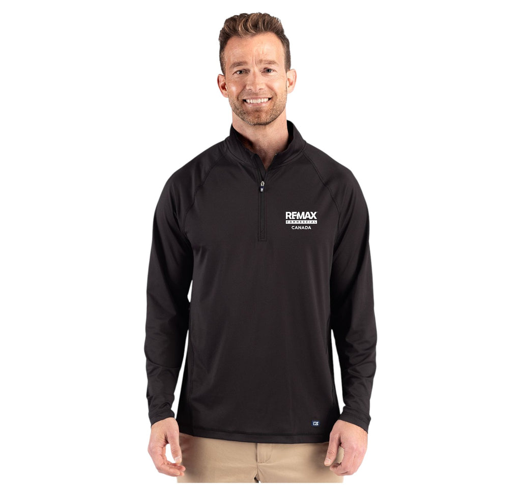 A man wearing a black long-sleeve quarter-zip pullover with a white 'REMAX' logo on the left chest, paired with khaki pants, against a plain white background.