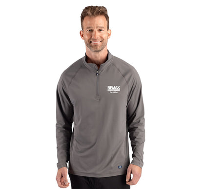 A man wearing a gray long-sleeve quarter-zip pullover with a white 'REMAX' logo on the left chest, photographed against a plain white background.
