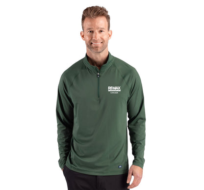 A man wearing a dark green long-sleeve quarter-zip pullover with a white 'REMAX' logo on the left chest, photographed against a solid white background.