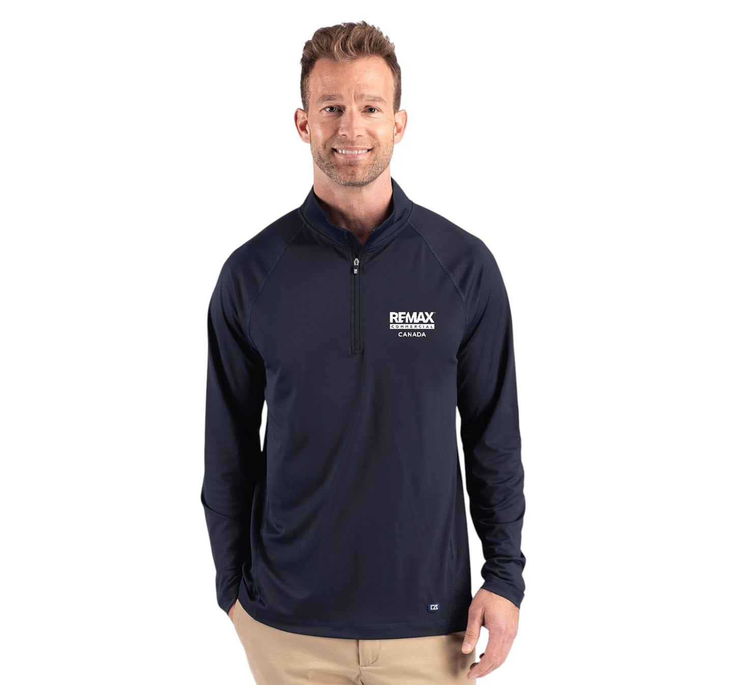 A man wearing a navy blue long-sleeve quarter-zip pullover with a white 'REMAX' logo on the left chest, paired with khaki pants, against a plain white background.