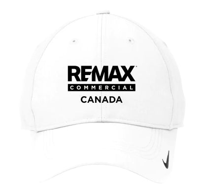 A white baseball cap featuring the black text 'REMAX COMMERCIAL CANADA' printed on the front, with a small black swoosh logo on the brim.