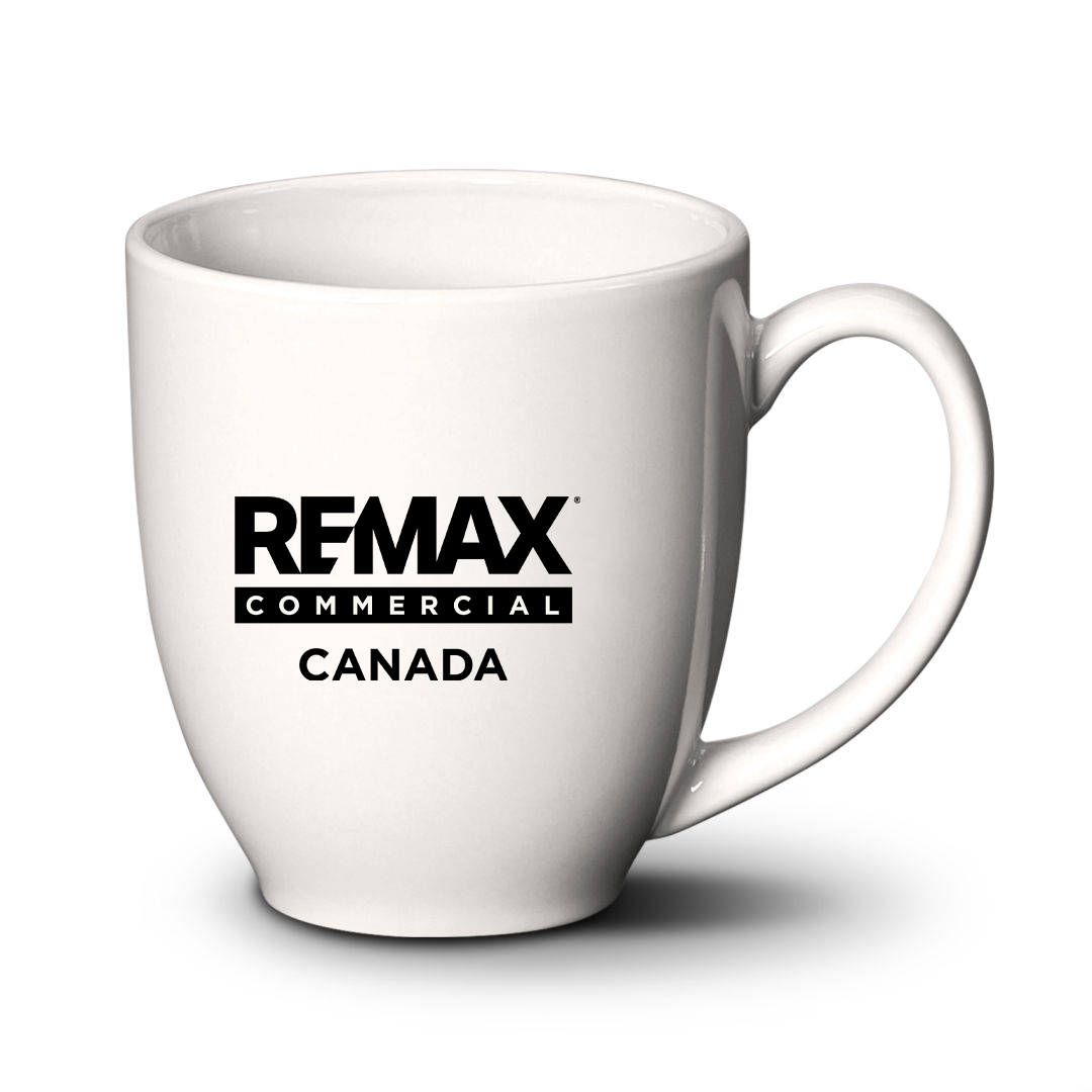 A white ceramic coffee mug with the black printed text 'REMAX COMMERCIAL CANADA' on the front, shown on a white background with a soft shadow.