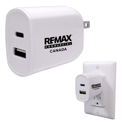 White RFMAX Commercial Canada USB-A wall charger shown from the front and plugged into a white wall outlet, on a light gray background.